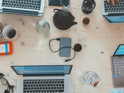 A bunch of laptops on a table from above